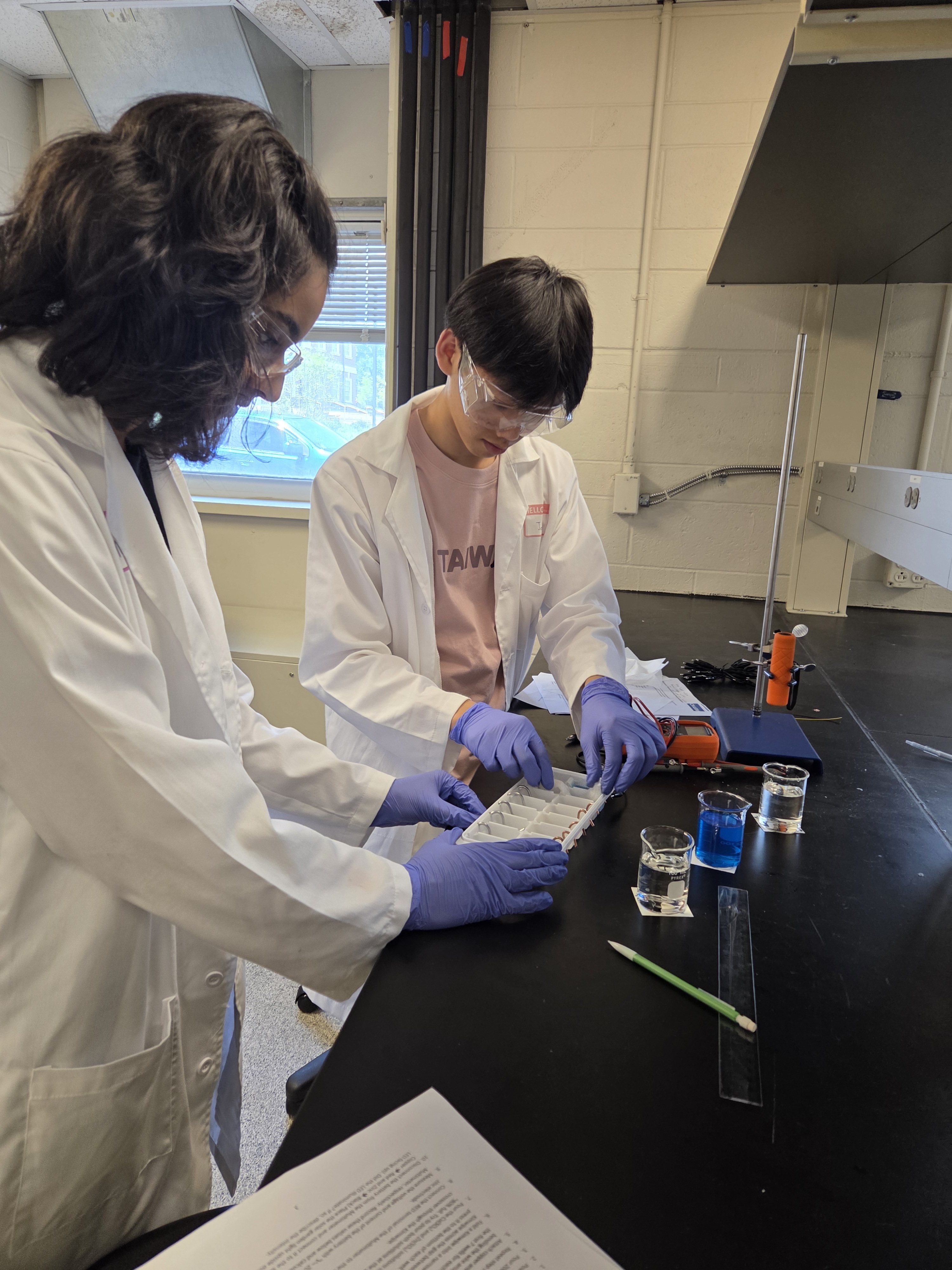 At a DuPont lab, FORGES students construct an electrochemical multi-cell battery using an ice cube tray, then measure its voltage. Image courtesy of Allison Landry.