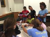 MRSEC undergraduates Lizzy Dresselhaus and Natasha Iotov demonstrate diffraction of light to 6th-8th grade middle school girls participating in the Girls in Engineering Math and Science (GEMs) summer camp. (Kagan)